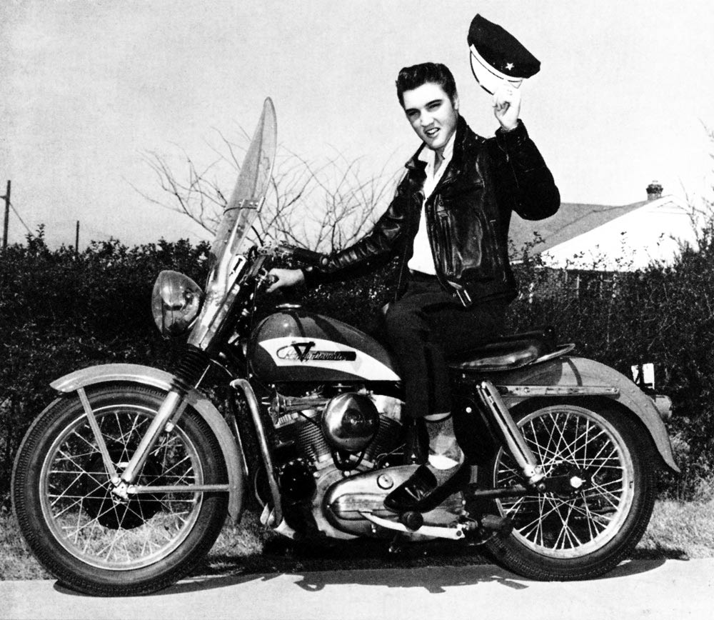 Elvis Presley sitting on Harley Davidson.
